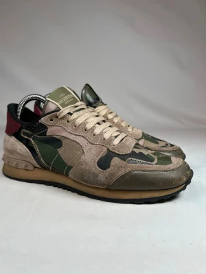Valentino rockrunners gröna! - Ett par feta Valentino rockrunners!!Grön camo med vinröd läpp där back.Passar perfekt nu till våren. Skick 8/10 100% äkta. 39 i italiensk storlek så passar 40/41.
