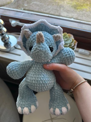 Virkad blå dinosaurie  - Söt virkad ljusblå dinosaurie. Ca 28 cm hög. Den har säkerhetsögon som inte är lämpliga för barn under 3 år💗