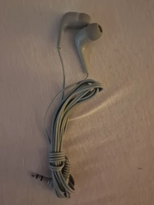 Gråa klassiska in-ear hörlurar - Säljer ett par gråa in-ear hörlurar med sladd och 3,5 mm AUX-kontakt. De har en enkel och stilren design, perfekt för dig som vill lyssna på musik eller poddar med klassisk kabelanslutning. Tillverkade i plast och gummi för bekväm passform. Sladden är väldigt lång! Dom är helt oanvända