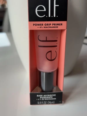 e.l.f. Power Grip Primer 24ml - Power Grip Primer från e.l.f. med 4% niacinamid. Transparent gel i en smidig tub med svart lock. Perfekt för att jämna ut huden och ge sminket bättre fäste. Innehåller 24 ml och passar alla hudtyper.