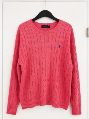Rosa kabelstickad tröja Polo Ralph Lauren - Snygg rosa kabelstickad tröja från Polo Ralph Lauren med rund halsringning och blå broderad logga på bröstet. Tröjan har långa ärmar och ribbade muddar vid ärmslut och nederkant. Perfekt för lager-på-lager och en chill stil.