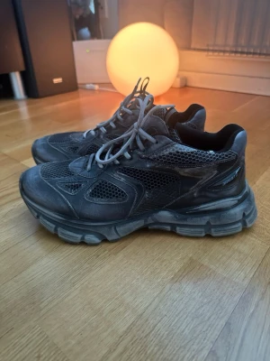 Grå sneakers från Axel Arigato - Snygga grå sneakers från Axel Arigato med meshpaneler och robust sula. Skorna har sportig vibe med detaljer i både textil och syntet, samt klassisk snörning. Perfekta för dig som gillar streetwear och vill ha en chunky look.