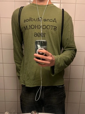 Ljusgrön långärmad tröja Acne Studios - Ljusgrön långärmad tröja från Acne Studios med tryck 'STOCKHOLM 1996' på bröstet. Tröjan har rund halsringning och avslappnad passform. Perfekt för en cool och enkel stil. Köpt från Acne i GBG för 3600kr i januari, kvitto finns. Storlek är väldigt missvisande. Jag är 188cm 80kg, sitter som en stor M för killar, för gizzarna sitter den som en stor L. Alltså oversized! Tredje bilden visar riktiga färgen, hör av om frågor eller flera bilder.