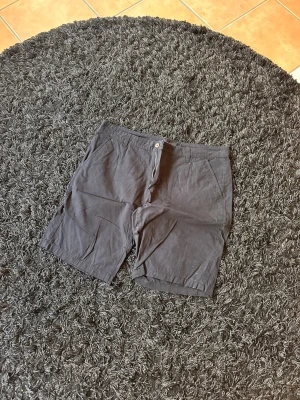 Svarta bomullsshorts med fickor - Klassiska svarta shorts i bomull med raka ben och normal passform. Shortsen har två sidofickor fram och två bakfickor med knapp. Perfekta för varma dagar och enkel stil.
