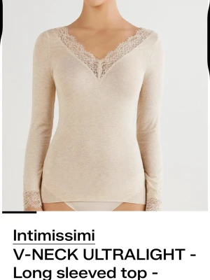Beige intimissimi tröja - Superfin beige långärmad topp från Intimissimi med v-ringning och spetsdetaljer vid halsringning och ärmslut. Tunn och mjuk, perfekt att styla till jeans eller kjol. Ultralätt material som känns skönt mot huden.