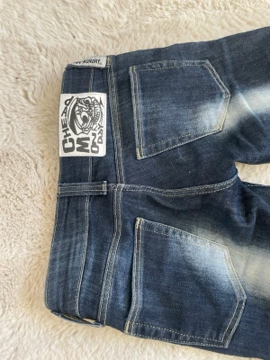 Mörkblå jeans från Cheap Monday - Snygga mörkblå jeans från Cheap Monday, även kallad kvarg jeans med slitna detaljer och kontrastsömmar. Klassisk femficksmodell och tydlig logga bak i midjan. Storlek 23 i midjan och 30 i längden. De är pytte lite slitna vid fötterna från att jag gått på dem ( finns bild) men det är väldigt litet och syns inte.