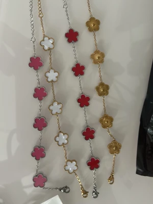 Färgglada armband med blommor - Säljer flera armband med blommor i rött, vitt och guld. Armbanden har kedjor i silver- eller guldfärg och blommorna är i emaljliknande material. Perfekt accessoar för att ge din outfit en lekfull touch.