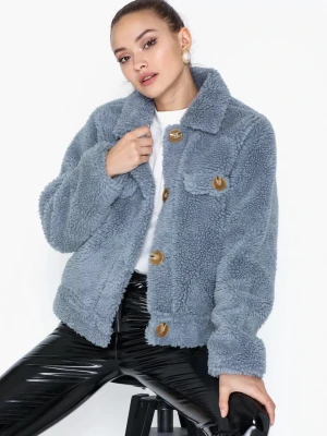 Blå teddyjacka med stora knappar - Säljer en supermjuk blå teddyjacka med stora bruna knappar och två bröstfickor. Jackan har en klassisk krage och är gjord i fluffigt teddy-material som håller dig varm och stylish. Perfekt till vår och höst.