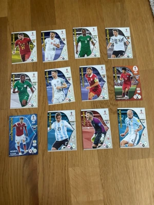 Panini VM 2018 samlarkort fotboll - Säljer ett gäng Panini Adrenalyn XL samlarkort från FIFA World Cup 2018. Korten har färgglada bilder på olika fotbollsspelare från olika nationer och är officiella trading cards. Perfekt för dig som gillar att samla på fotbollskort eller vill byta med vänner.