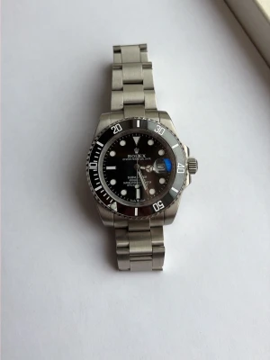 Klocka submariner  - Säljer en snygg svart submariner klocka. Alla tillbehör på bilderna skickas med. Klockan är endast testad. 