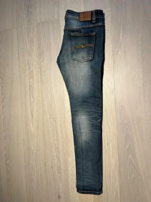 Nudie Jeans Thin Finn - Nudie Jeans med schyssta slitningar.                        Skick 8/10.                                                                  Liten skavank (sista bilden).                                                                               Längd: 102cm.                                                                 Midja:41cm.                                                                                 Skriv om du har frågor❗️.                      