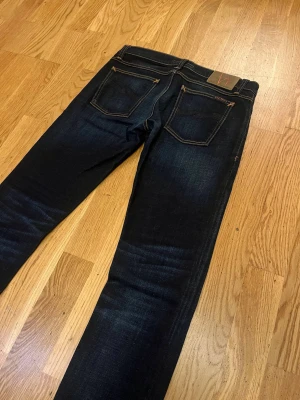 Nudie jeans - Säljer ett par feta mörkblå jeans från Nudie. Jeansen är i nyskick och har en snygg tvättning! Modell Long John/de är ganska slim och storlek 30/32! Skriv vid minsta funderingar
