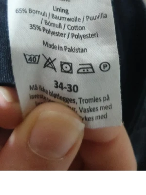 Mörkblå jeans 34-30 - Säljer ett par mörkblå jeans med klassisk femficksmodell. Jeansen är tillverkade i 65% bomull och 35% polyester, vilket ger en skön och slitstark känsla. Passformen är rak och färgen är djupblå, perfekt till en avslappnad stil.