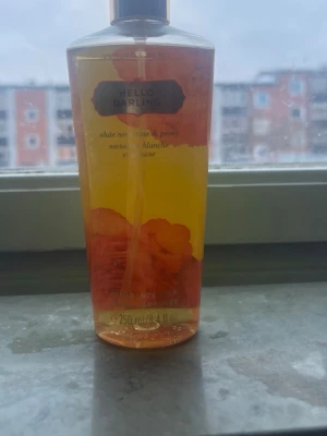 Victoria's Secret Hello Darling parfym - Fräsch parfym från Victoria's Secret i doften Hello Darling. Flaskan är genomskinlig med gul och orange färg och har blommiga detaljer. Innehåller 250 ml och har noter av vit nektarin och pion. Perfekt för dig som gillar söta och fruktiga dofter. använd knappt 