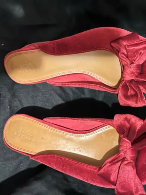 Röda ballerinaskor med rosett - Säljer ett par eleganta röda ballerinaskor från ASOS DESIGN i sammetsmaterial. Skorna har spetsig tå och en stor dekorativ rosett framtill som ger en trendig look. Perfekta för dig som vill sticka ut med snygga detaljer.