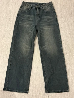 Baggy blågråa jeans  - Säljer ett par baggy blågråa jeans med raka ben.  Jeansen har en tvättad look med ljusa slitningar framtill och baktill. Säljer då de ej har kommit till användning🥰pris går att diskuteras