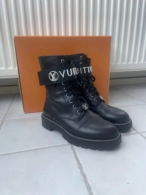 Louis Vuitton Territory Flat Ranger Boots EU 37,5 - Louis Vuitton Territory Flat Ranger Boots  Dessa säljs inte längre på LV.  Original box och kvitto från LV medföljer!   På bilden på kvittot har jag suddat ut mitt namn men det kommer att vara synligt på kvittot som medföljer. Dom är köpta 26 Nov 2021.  Storlek 37,5 Skick: Mycket fint, sparsamt använda. 