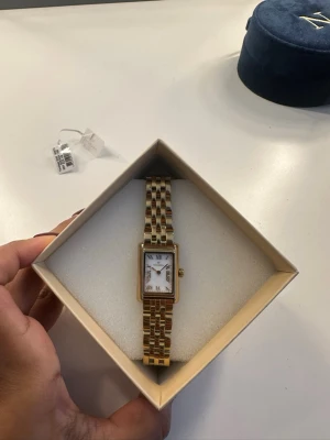 Mockberg klocka guld  - Säljer en klocka ifrån Mockberg i modellen Timeless Watch i färgen guld. Använd men väldigt bra skick. Har några små report i högra hörnet men ingeting som syns tydligt( bild 2), syns mest på nära håll. Låda och extra länkar skickas självklart med klockan! 