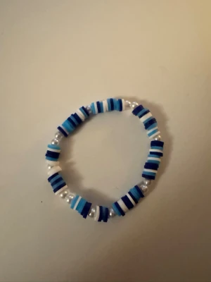 Hedwig bracelet💗 - Säljer ett handgjort armband med pärlor i olika nyanser av blått och vitt. Armbandet har elastisk tråd och består av platta och runda pärlor som ger en cool och lekfull look. Perfekt accessoar för att addera färg till din outfit.