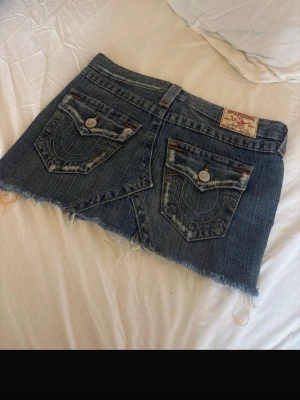 True religion jeanskjol - Superfin lågmidjad jeanskjol från märket true religion. Storlek 25-26 ( lappen är bortklippt) men passar mig som har XS, kjolen är kort och lågmidjad och är superfin, (visar inga bilder på) Deffekt: Dragkedjan är sönder men det syns ej när kjolen är på och det är dessutom lätt att laga själv hemma om man är pysslig av sig. Annars har jag bara satt en säkerhetsnål där och det har funkat super. Mått: 30 cm på längden, 40 cm tvärs över på midjan.