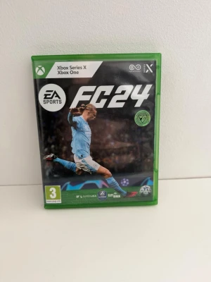 EA Sports FC24 Xbox Series X/One - Säljer spelet EA Sports FC24 till Xbox Series X och Xbox One. Spelet kommer i ett grönt plastfodral med omslagsbild på en fotbollsspelare och inkluderar skiva samt informationshäfte. Perfekt för dig som gillar fotbollsspel och vill bygga ditt drömlag. Använd men i gott skick