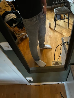 Grå slim fit jeans - Säljer ett par grå slim fit jeans med klassisk femficksmodell och normal midja. Jeansen har en snygg tvättad look och raka ben. Passar perfekt till en avslappnad stil och är lätta att matcha med olika plagg. 29/30. Köpte på Jack Jones 