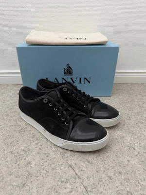 Svarta Lanvin sneakers med vit sula - Snygga Lanvin dbb1 patent cap toe | storlek 11 eu45 | skick som på bilder | allt ingår äktighetsbevis finns | vårdade med sulkräm | pris går att diskutera vid snabb affär |