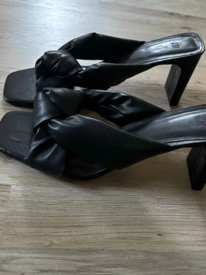 Svarta klackskor - Svarta klackskor från H&M. Skorna är öppna och har en medelhög klack .