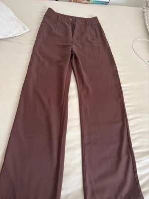 Bruna kostymbyxor  - Storlek 34, passar 36. Är 160 cm och de går ändra ner till hälarna på mig. Skönt material, finns även i svart. 