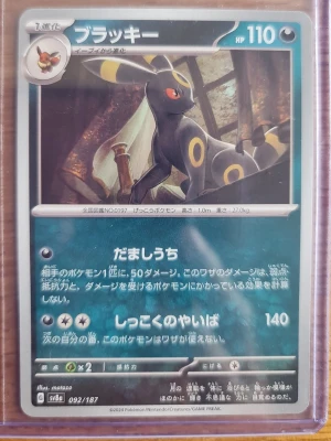 Japanskt Umbreon Pokémonkort - Säljer ett japanskt Umbreon (Blacky) Pokémonkort från Scarlet & Violet-serien, nummer 092/187. Kortet har en snygg illustration med mörka och gula färger och är tillverkat i klassiskt Pokémonkort-material. Perfekt för samlare eller Pokémonfans.