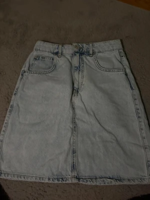 Ljus jeanskjol med fickor - Säljer en ljusblå jeanskjol i klassisk modell.