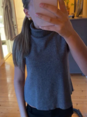 Grå armlös polotopp - Grå armlös polotopp med ribbad krage 