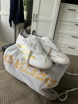 Adidas predator elite fold-over  - Snygga adidas fotbollskor i storlek 44. Använda men i väldigt fint skick, använda mest av mig som domare. Kostar 3200 nya. Man får med en påse men den har en liten skada(se bild) men den syns inte när den används 