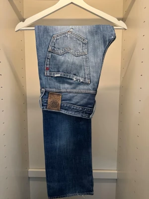 Replay ”Waitom” Jeans - Säljer mina bästa Replay ”Waitom” jeans jag ägt, extremt fet tvätt och slitningar runt hela byxan. Skicket är grymt, finns lagat hål mellan benen och lagad ficka, men inget som syns eller stör sig på vid användning. Alla andra slitningar har kommit med tiden, vilket bara gör att dom ser fetare ut. Storleken är 32/32. Sista bilden visar hur det sitter på. KAN GÅ NER I PRIS VID SNABB AFFÄR! 💎