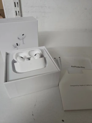 Apple AirPods Pro trådlösa hörlurar - Säljer ett par vita Apple AirPods Pro med laddningsetui. Hörlurarna är kompakta, har silikonproppar och levereras i originalförpackning med tillhörande manualer. Snygg och stilren design i blankt plastmaterial, perfekt för dig som vill ha grymt ljud och smidig anslutning.