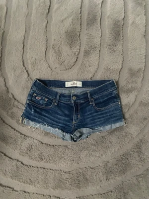 mörkblå jeansshorts - hollister - snygga mörkblå jeansshorts från hollister. shortsen har låg midja och detaljerade sömmar samt en liten logga på fickan fram. perfekt till sommaren och enkel att styla!! (INTRESSEKOLL därav priset!!)