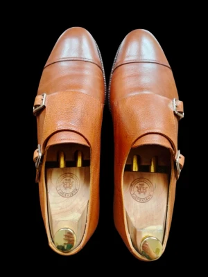 Meermin monkstrap loafers - Snygga bruna loafers ifrån Meermin med dubbla monkstrap-spännen och rundad tå. Skorna är tillverkade i slätt och lätt texturerat läder (Goodyear konstruktion) med gummisula (Danite) för extra grepp. Klassisk design som passar till många olika stilar.