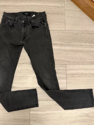 Svarta anbass jeans från Replay w31 L34 - Säljer ett par svarta anbass jeans från Replay. Jeansen har en smal passform och är tillverkade i stretchigt denimtyg för extra komfort. Perfekta till sneakers eller boots. Skeiv gärna om du undrar något och pris kan spklart diskuteras.