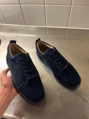 Mörkblå mockasneakers - Snygga mörkblå sneakers i mocka med matchande mörkblå skosnören och svart sula. Skorna har en klassisk låg design och en stilren look som passar till det mesta. Insidan är ljusbeige för extra kontrast. Perfekta för dig som gillar enkel men trendig stil.