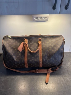 Louis Vuitton Keepall Bandouilere 55L - Säljer nu en oerhört fräsch Louis Vuitton Keepall Bandouilere  Storlek 55L  ÄKTA  Mycket bra skick! , små defekter förekommer vilket är vanligt.