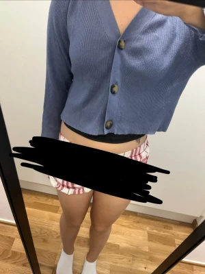 Blå cropped kofta med stora knappar - Säljer en blå cropped kofta med tre stora knappar framtill. Koftan har ribbad struktur, V-ringning och långa ärmar. Perfekt för att slänga över ett linne eller t-shirt för en chill look.