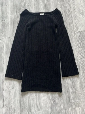 Svart ribbad stickad klänning från H&M - Säljer en svart ribbad stickad klänning med lång ärm och rundad halsringning. Klänningen har en kroppsnära passform och är perfekt för dig som gillar en enkel men stilren look. Passar till många olika tillfällen och är superbekväm. Helt ny oanvänd