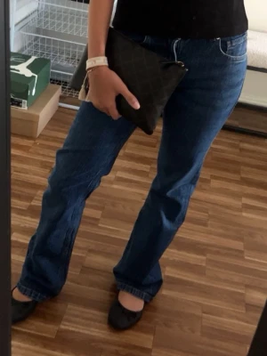 Blå bootcut jeans - Säljer ett par klassiska blå bootcut jeans och femficksmodell. Jeansen har en snygg tvätt och raka ben som går ut lite nedtill. Perfekta till sneakers eller ballerinas. Materialet är denim i bomull. Från bikbok
