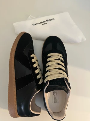 Maison Margiela svarta sneakers - Säljer ett par Maison Margiela i svart färg, storlek 42. Skorna är i nyskick och aldrig använda. Kommer med originalförpackning. Vid intresse eller frågor tveka inte att höra av er. 