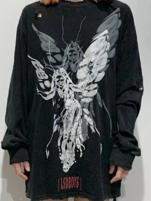 Svart oversized tröja - Cool svart oversized långärmad topp från LSDBOYS med stort vitt och grått tryck av en ängel och textdetalj nedtill. 