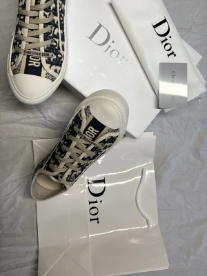 Walk n Dior Oblique embroid  Sneakers  - Snygga Dior Oblique sneakers i canvas med klassiskt blått och vitt mönster och vita snören. Tjock vit sula med stjärndetalj undertill och 'Made in Italy' präglat. Märkeslogga på plösen och sidan. Perfekta för dig som vill ha en exklusiv och trendig look.(KVITTO FINNS) (priset är inte hackat i sten  helt ny köpte fel storlek till syrran därför säljer jag  
