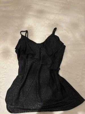 Glittrigt linne med volang - Knappt använd