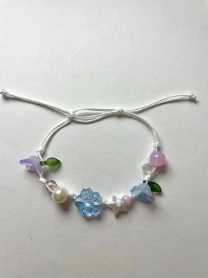 Armband med blommor - Lila och blått armband med blommor🌸 kommer fint inpackat med gåvor