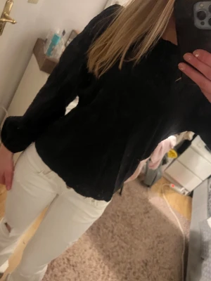 Svart blus med puffärm - Snygg svart blus med puffiga långärmar och rund halsringning. Blusen har en lätt strukturerad yta som ger en cool touch till outfiten. Perfekt att styla med jeans eller kjol för en trendig look.