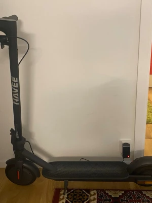 Svart el-scooter från Navee  - Elektrisk scooter i svart från Kavee med robust ram och bred fotplatta. Scootern har handtag, stora hjul och laddas via medföljande laddare. Perfekt för att ta sig runt i stan på ett smidigt sätt. Den kör 20 km/h 